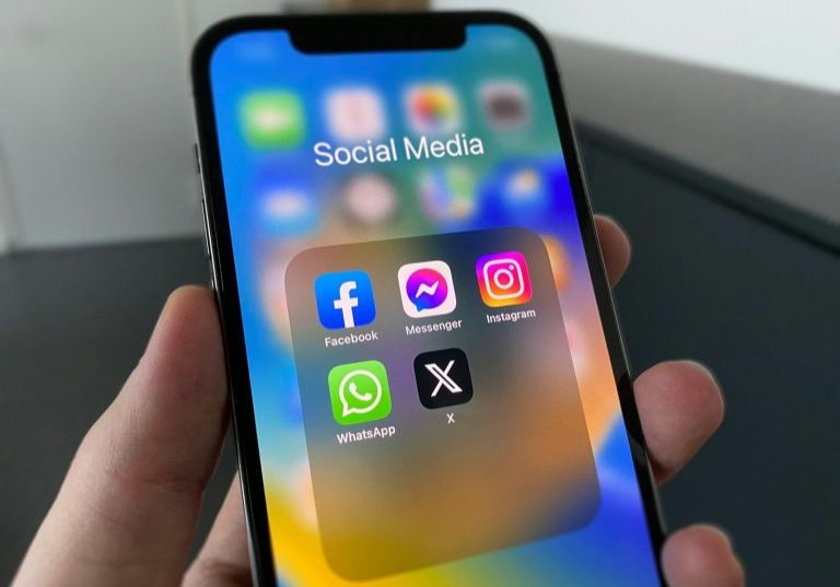 a person holding a cell phone with social media on the screen