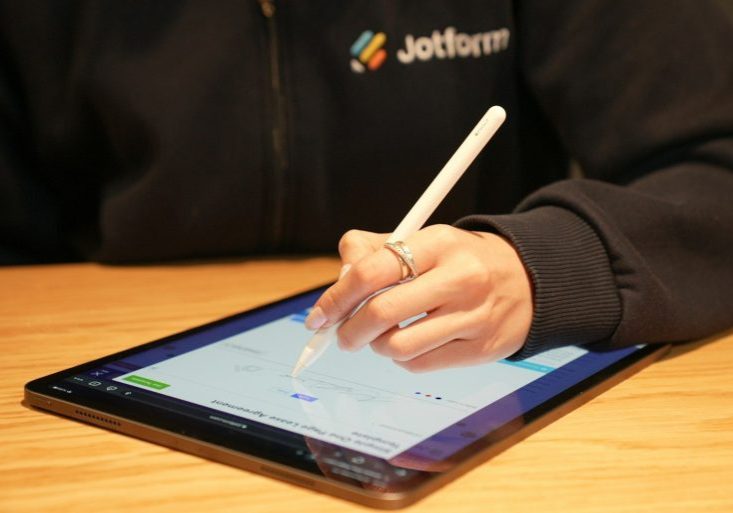 a person writing on a tablet with a pen