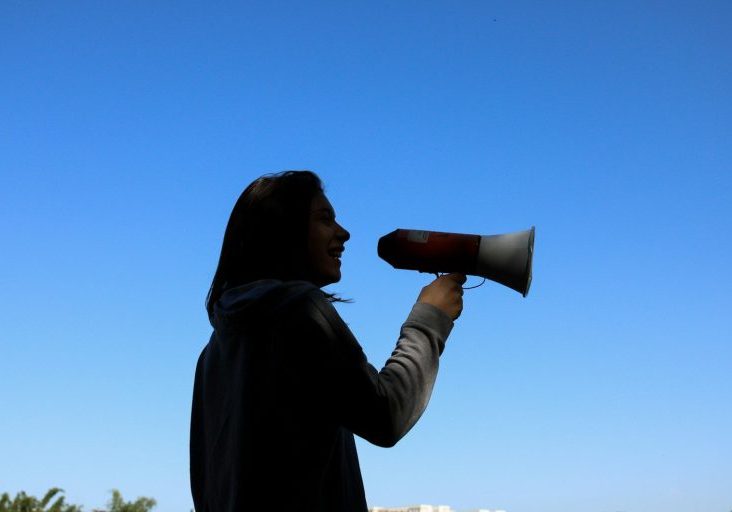 man in black hoodie drinking from a bottle